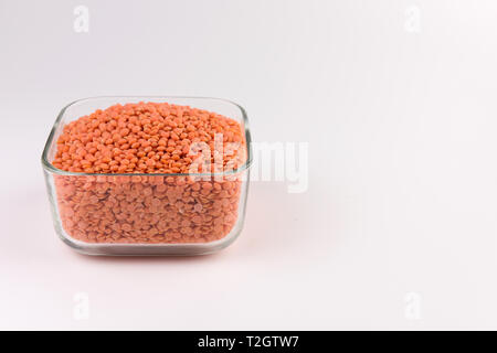 Rote Linsen in der Glasplatte auf weißem Hintergrund Stockfoto