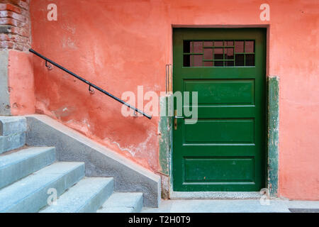 Alten grünen Holztür, Rot geschrumpfte Wand, Treppen mit Geländer, perfekt ausgerichtet eine abstrakte Stadt Szene zu bilden. Alte traditionelle Straße in der Nähe von Sibiu ci Stockfoto