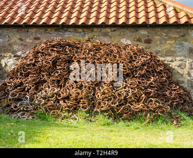 Haufen rostiges Hufeisen durch alte Schmiede in der Erhaltung Dorf East Saltoun, East Lothian, Schottland, Großbritannien Stockfoto