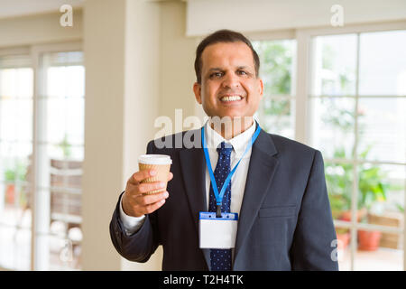 Mittleres Alter Geschäftsmann, trinken eine Tasse Kaffee tragen ID-Karte Stockfoto