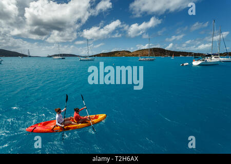 Zwei Frauen, die an einem sonnigen Tag auf den Britischen Jungferninseln in hellblauem Karibikwasser Kajakfahren Stockfoto