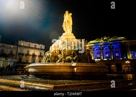 Blick auf die Statue der Drei Grazien in der Nacht mit Oper auf dem Hintergrund in Montpellier Stadt in Frankreich Stockfoto