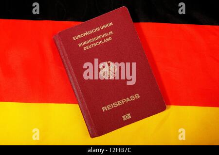 Biometrischer Reisepass der Bundesrepublik Deutschland, der Europäischen Union, Schwarz-Rot-Goldenen deutschen Nationalflagge hinter, Deutschland Stockfoto