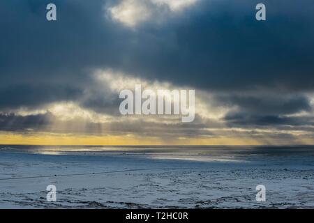 Sonnenlicht strahlt durch dunkle Wolken am Meer scheint, im Winter, Halbinsel Snaefellsnes, Island Stockfoto