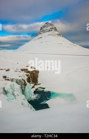 Gefrorenen Wasserfall Kirkjufellsfoss und die Berge mit Schnee, Kirkjufell Halbinsel Snaefellsnes, Vesturland, Island Stockfoto