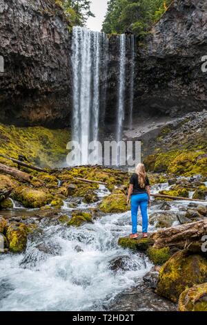 Junge Frau, die an einem Fluss, Wanderer, Wasserfall stürzt über Felsvorsprung, Tamanawas fällt, wilden Fluss Cold Spring Creek, Oregon, USA Stockfoto