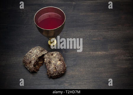 Gemeinschaft und Leidenschaft - ungesäuertes Brot Kelch Wein auf hölzernen Tisch Stockfoto