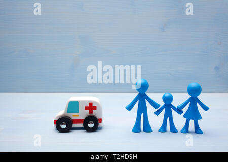 Familie Figuren auf Blau Holztisch, Krankenversicherung Konzepte Stockfoto