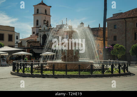 Anmutige Brunnen mit Wasser spritzen auf einem Platz vor der Kirche in Merida. Die Stadt bewahrt viele Gebäude des antiken Roms in Spanien. Stockfoto