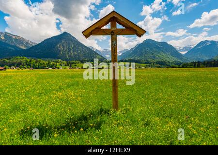 Feld Kreuz mit Christus Figur vor der Berglandschaft, Loretto Wiesen in der Nähe von Oberstdorf, dahinter Gaisalphorn, Nebelhorn, Schattenberg und Stockfoto