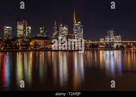 Skyline von Frankfurt mit beleuchteten Wolkenkratzer und Reflexionen in den Main, Schaumainkai, Frankfurt am Main, Hessen, Deutschland Stockfoto