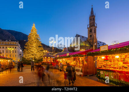 Bozen Kathedrale und lange Belichtung der Kunden an Weihnachtsmarkt auf der Piazza Walther, Bozen, Italien, Europa Stockfoto