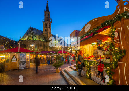 Bozen Kathedrale und lange Belichtung der Kunden an Weihnachtsmarkt auf der Piazza Walther, Bozen, Italien, Europa Stockfoto