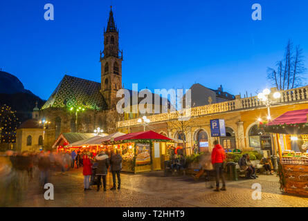 Bozen Kathedrale und lange Belichtung der Kunden an Weihnachtsmarkt auf der Piazza Walther, Bozen, Italien, Europa Stockfoto