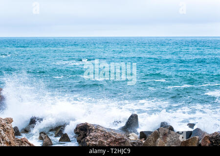 Natur Hintergrund mit Wellen brechen gegen das Meer steinigen Ufer Stockfoto