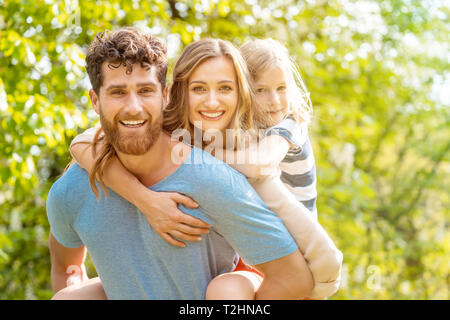 Starker und zuverlässiger Mann seine Familie unterstützt durch die Frau und Sohn piggyback Stockfoto