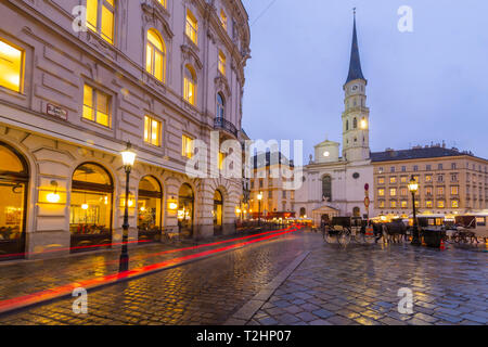 Weihnachtsmarkt Stände und St. Michael Katholische Kirche in Michaelerplatz, Wien, Österreich, Europa Stockfoto