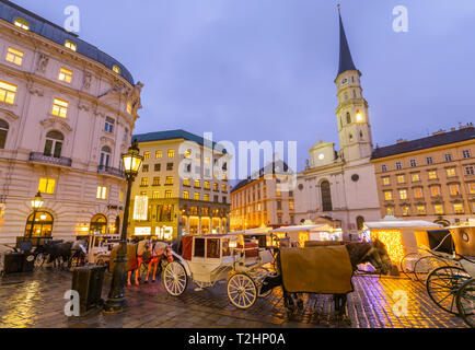 Weihnachtsmarkt Stände und St. Michael Katholische Kirche in Michaelerplatz, Wien, Österreich, Europa Stockfoto