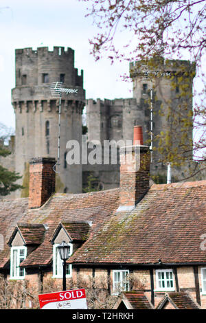 Die Altstadt von einem Immobilienmakler'-Zeichen wird durch Wohnhäuser in der Nähe von mittelalterlichen Schloss Warwick in Warwick, Warwickshire, Großbritannien gesehen. 2.April 2019. Stockfoto