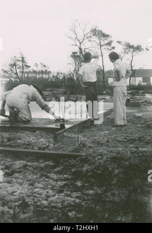 Antike c1950 Foto, Mann mit einem Betonschweben auf neue Grundlage gegossen in einen Rahmen. Standort unbekannt, USA. QUELLE: ORIGINAL FOTODRUCK. Stockfoto