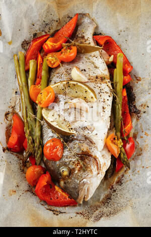 In vergoldeten Kopf Brassen gebraten mit Gemüse in der Papier-, close-up Stockfoto