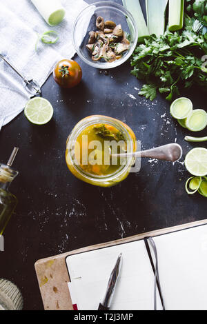 Minestrone Rezept, Verkostung und Schreiben rcipe auf Koch Buch über italienische Minestrone, auf ein Glas Glas. mit Cherry Tomaten Braun, Kalk, und Link roun Stockfoto