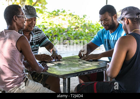 La Dique, Seychellen - Februar 4., 2019: Vier lokale Männer playinig Domino im Freien in La Digue, Seychellen. Stockfoto