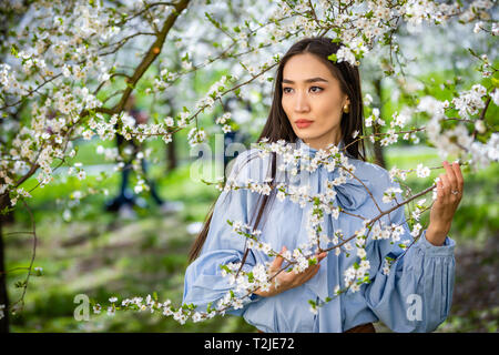 Schöne junge Asiatin in Blooming Apple Blüten Garten in Prag Stockfoto