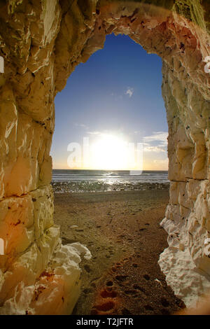 Blick auf den Sonnenuntergang von einer Höhle in der Kreidefelsen in der Nähe von Beachy Head Eastbourne, East Sussex, Großbritannien Stockfoto
