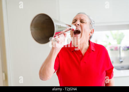 Älterer Mann shouthing durch vintage Metall Megaphon aufgeregt Stockfoto