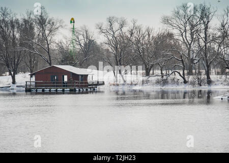 Zwei Fischer auf einer überdachten Angeln Dock auf einem See in Sedgwick County Park in Wichita, Kansas, USA nach einer späten Winter Schneefall. Stockfoto