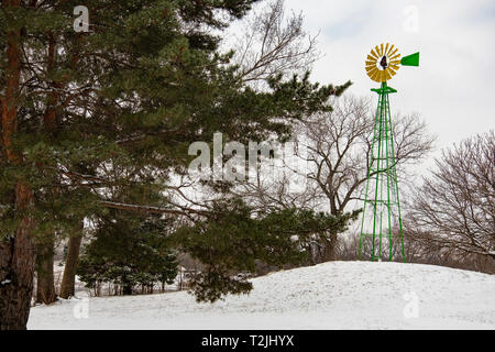 Windmühle, Gelb und Grün, in Sedgwick County Park nach einem späten Winter Schnee. Wichita, Kansas, USA Stockfoto