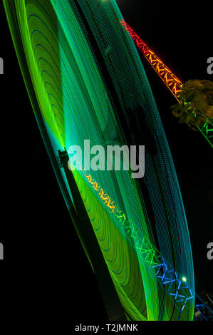 Grünes Licht Fahrgeschäft nachts Spinnen Stockfoto