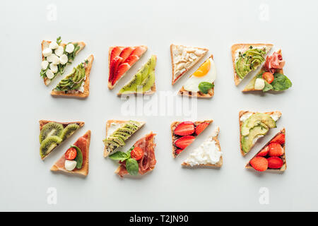 Blick von oben auf die leckeren Toast mit Obst und Gemüse isoliert auf weißem Stockfoto