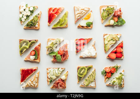Blick von oben auf die leckeren Toast mit Obst und Gemüse isoliert auf weißem Stockfoto