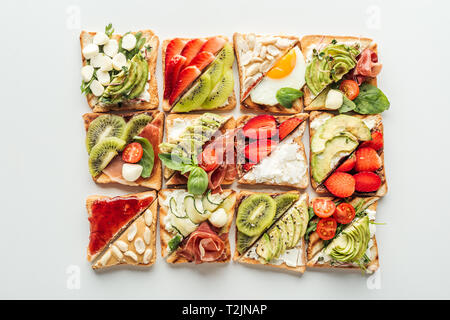Blick von oben auf Toast mit frischem Obst und Gemüse isoliert auf weißem Stockfoto