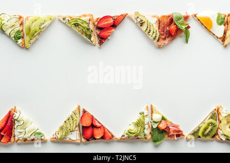 Blick von oben auf Toast mit frischem Obst und Gemüse auf Weiß mit Kopie Raum isoliert Stockfoto