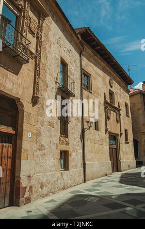Gasse und alte Gebäude aus Stein mit Balkonen, an einem sonnigen Tag in Salamanca. Die Stadt bewahrt viele Gebäude des antiken Roms in Spanien. Stockfoto