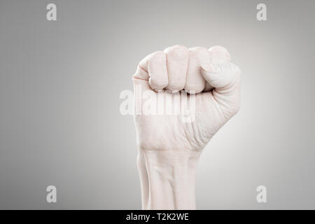 7/8-Ansicht der weiblichen Hand in Weiß mit Faust auf Grau lackiert Stockfoto