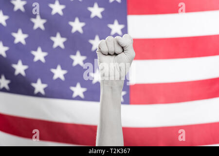 Ansicht der weiblichen Hand in Weiß mit Faust in der Nähe der amerikanischen Flagge bemalt 7/8 Stockfoto