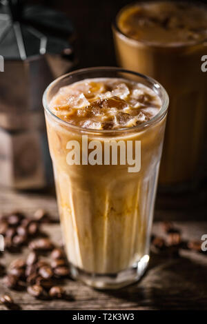 Lecker lecker erfrischenden kalten Kaffee mit Eis und Sahne Milch in Gläser. Bereit für das Trinken. Auf alten hölzernen Tisch serviert. Stockfoto