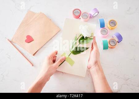 Die Dekorationen oder Grußkarte. Papierstreifen, Blume, Schere. Kunsthandwerk im Urlaub: Geburtstag, Muttertag oder Vatertag, 8. März, Hochzeit. Stockfoto