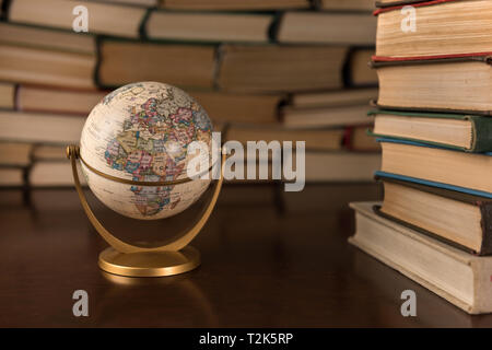 Globus und viele Bücher auf einem Holztisch Stockfoto
