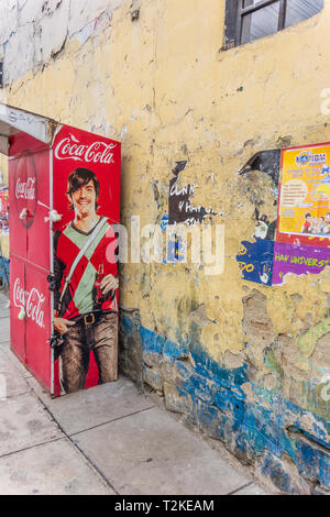 Ein Getränkeautomat, Coca Cola Maschine mit einem Porträt auf Ihrer Seite auf einem Bürgersteig in Cochabamba, Bolivien gemalt. Stockfoto