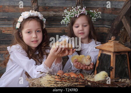 Zwei Mädchen halten Hühner. Ostern Stockfoto