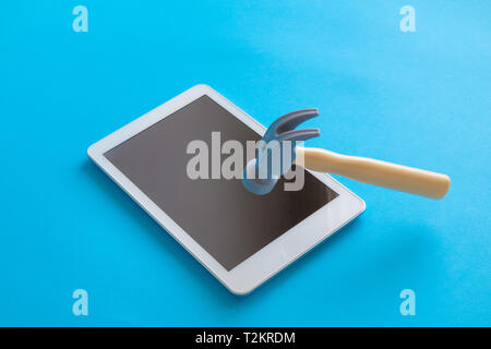 Brechen digital Tablet-PC oder Smartphone mit Kunststoffhammer minimal kreatives Konzept. Stockfoto