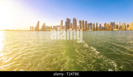 Stadtbild von Doha West Bay Skyline von Bootsfahrt in Doha Bucht bei Sonnenuntergang. Hölzernen Dhaus nehmen Touristen um die Bucht herum. Katar, Naher Osten, Arabische Stockfoto