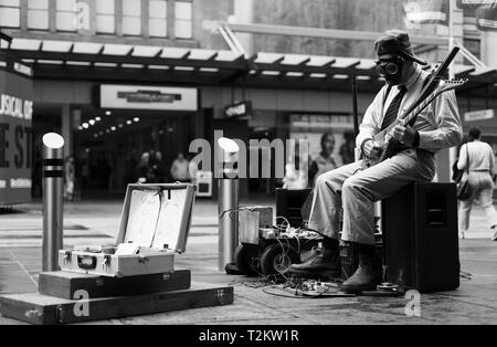 Straße busker Gitarre spielen mit einer Gasmaske auf Stockfoto