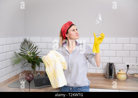 Frau Reinigung oder ruges Glas in der Küche. haushälterin tun Frühjahrsputz Stockfoto