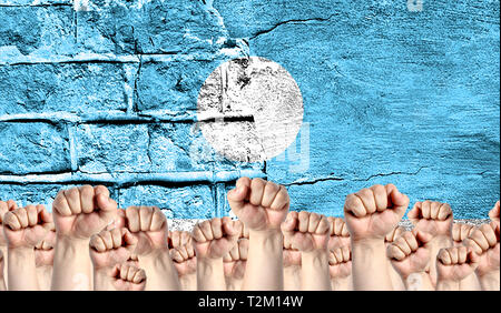 Männliche Hände umklammerten in der Faust, vor dem Hintergrund einer zerstörten Mauer mit einer Flagge der Republik Sacha angehoben. Das Konzept des Arbeitsmarktes movemen Stockfoto